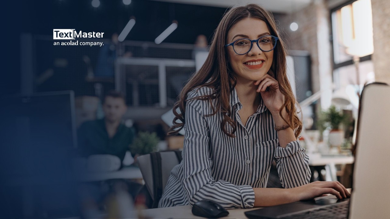 Woman sitting at her desk, smilling, and Textmaster logo