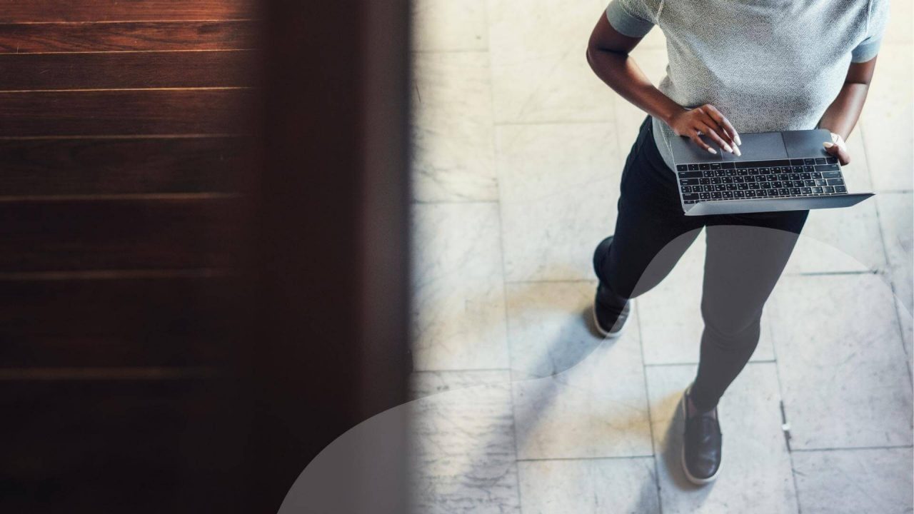 A man works at a laptop while walking