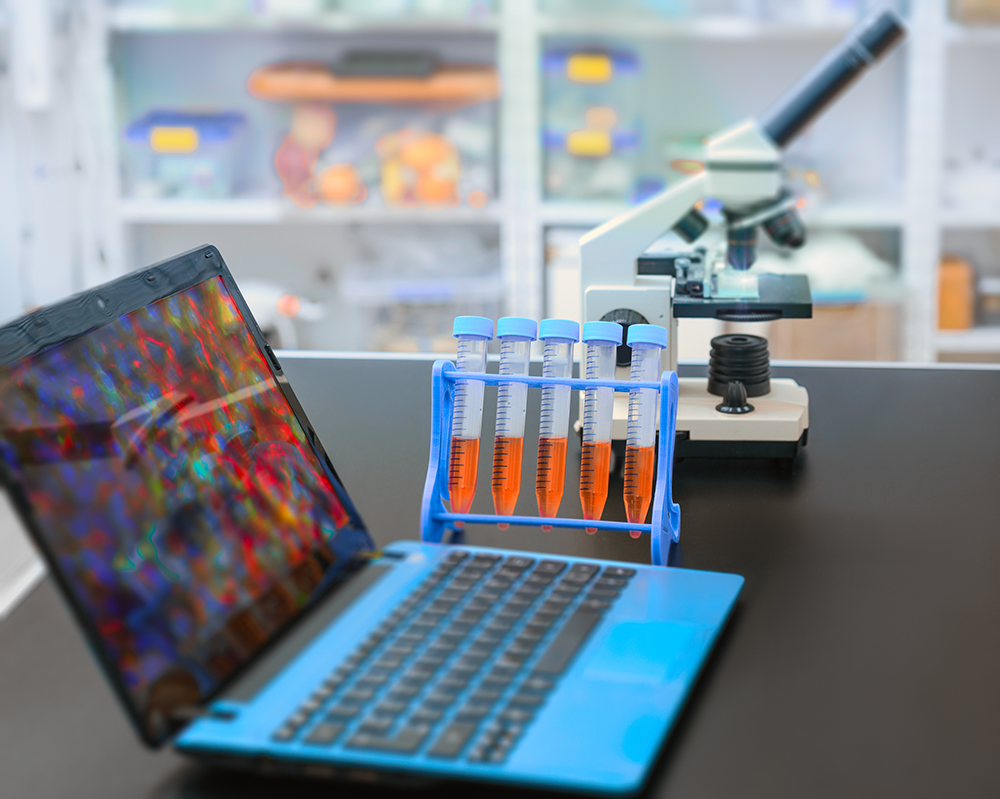 Microscope and laptop with digital microscopic image in research facility