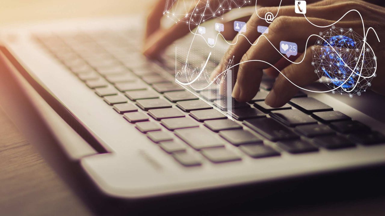 Hands interacting with a laptop keyboard, illustrating the concept of social media engagement, online communication, and digital networking.