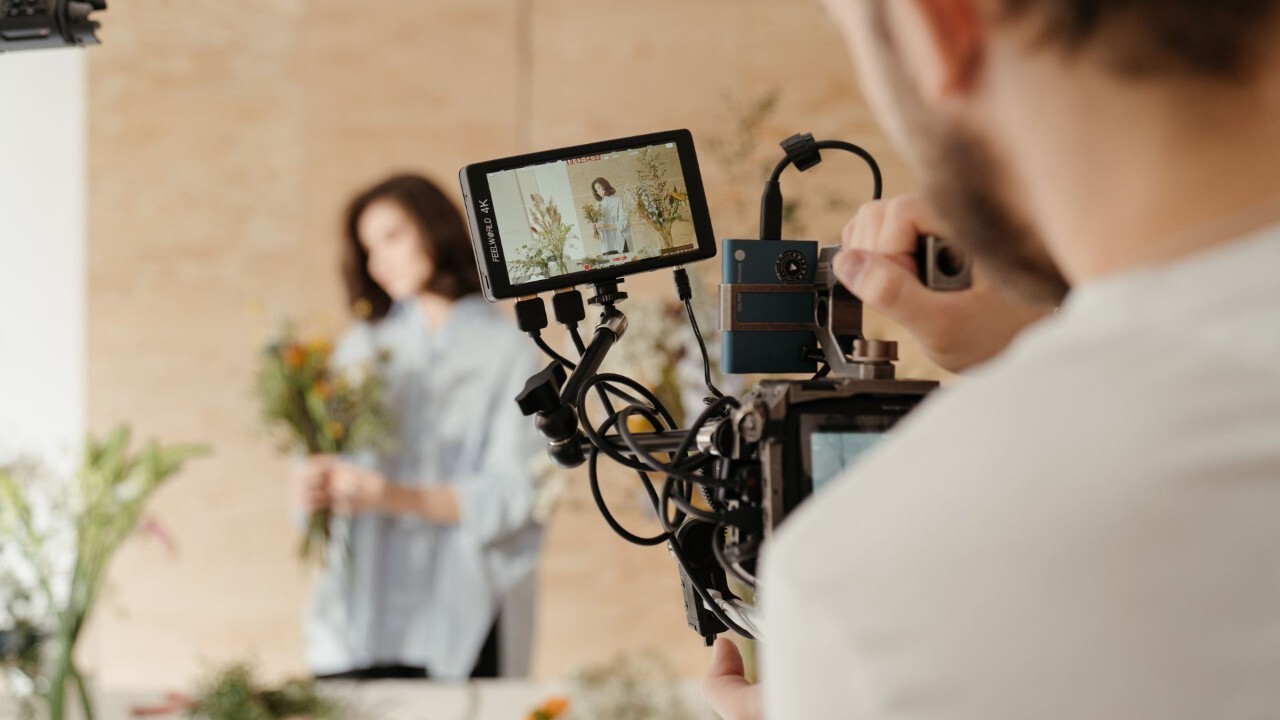 close perspective of video camera filming woman with flowers