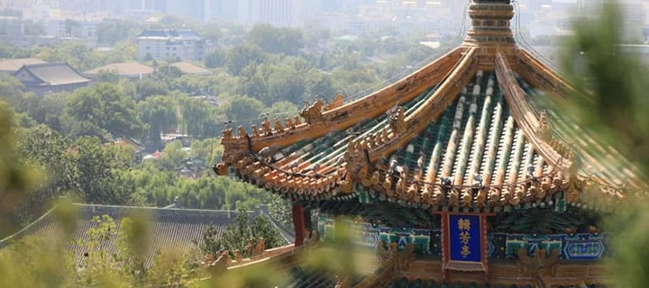 En naturskøn udsigt i Beijing, Kina, med en traditionel pavillon og de ikoniske vartegn Jingshan Park, Den Forbudte By og Himlens Tempel i det fjerne.