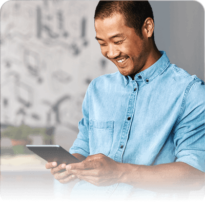 Man standing and smiling using tablet