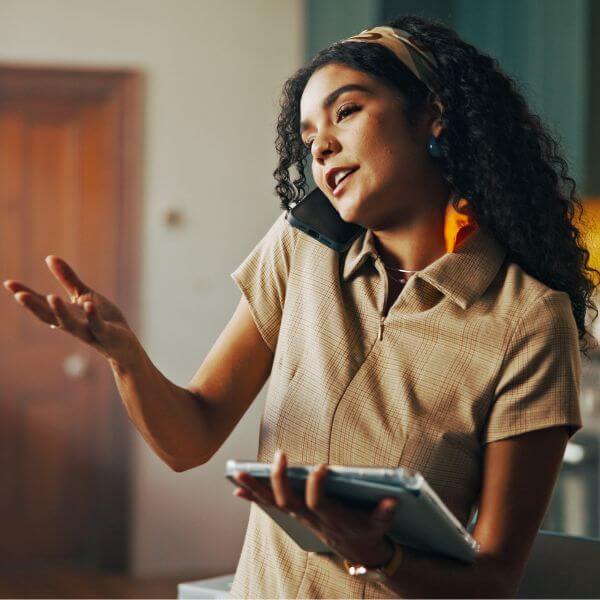 business woman on a phone call while holding a tablet