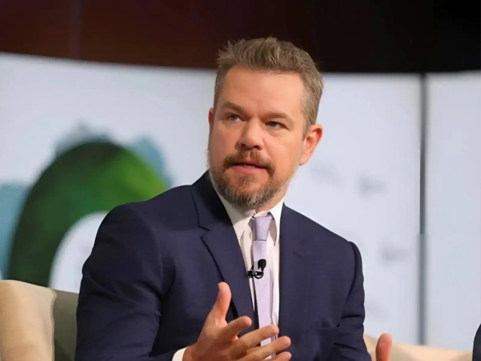 Matt Damon speaking on-stage at event with live interpreting