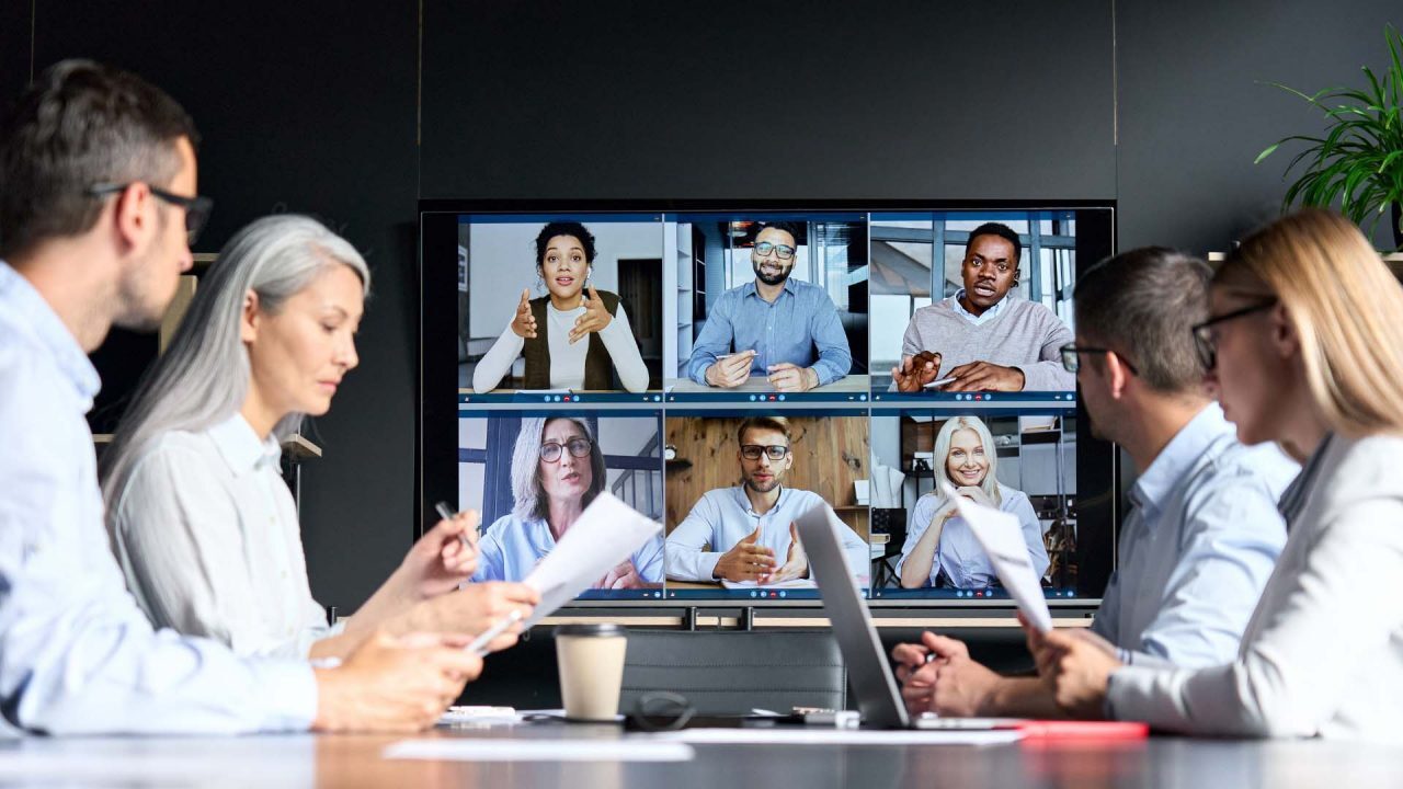 business meeting with both in-person attendees and remote participants on screen