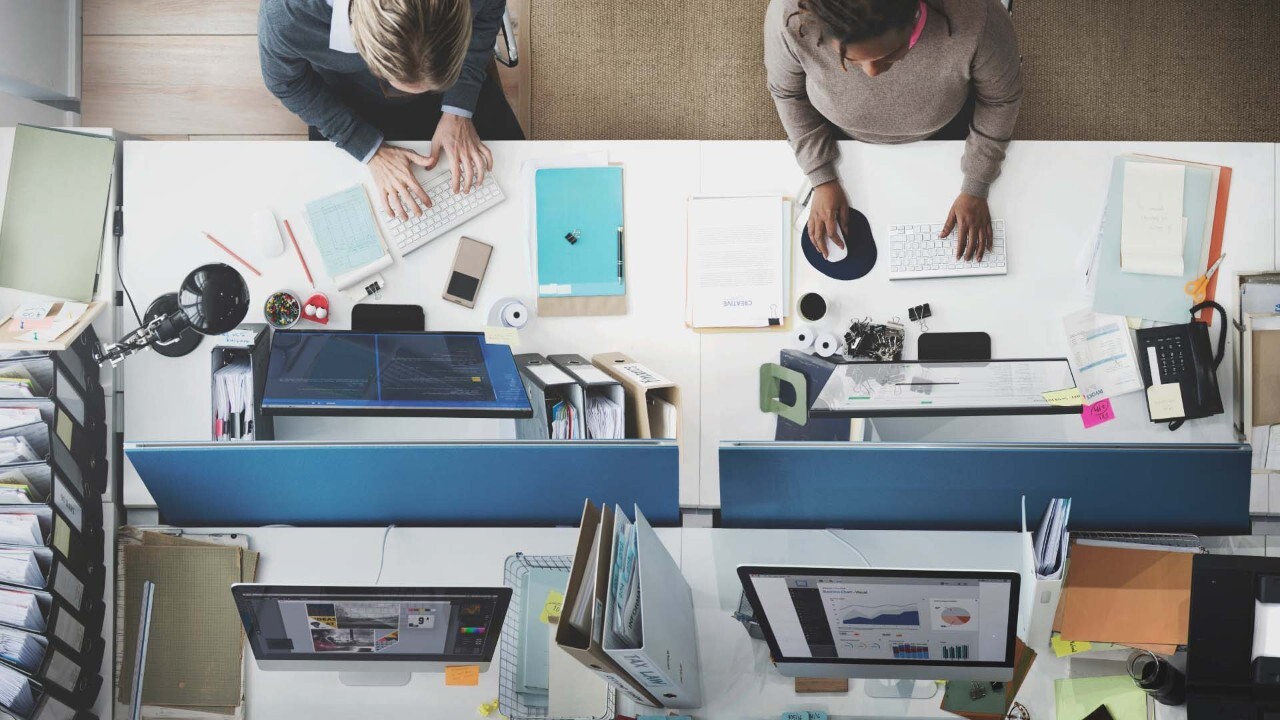 office workstation view from above with people at their computers