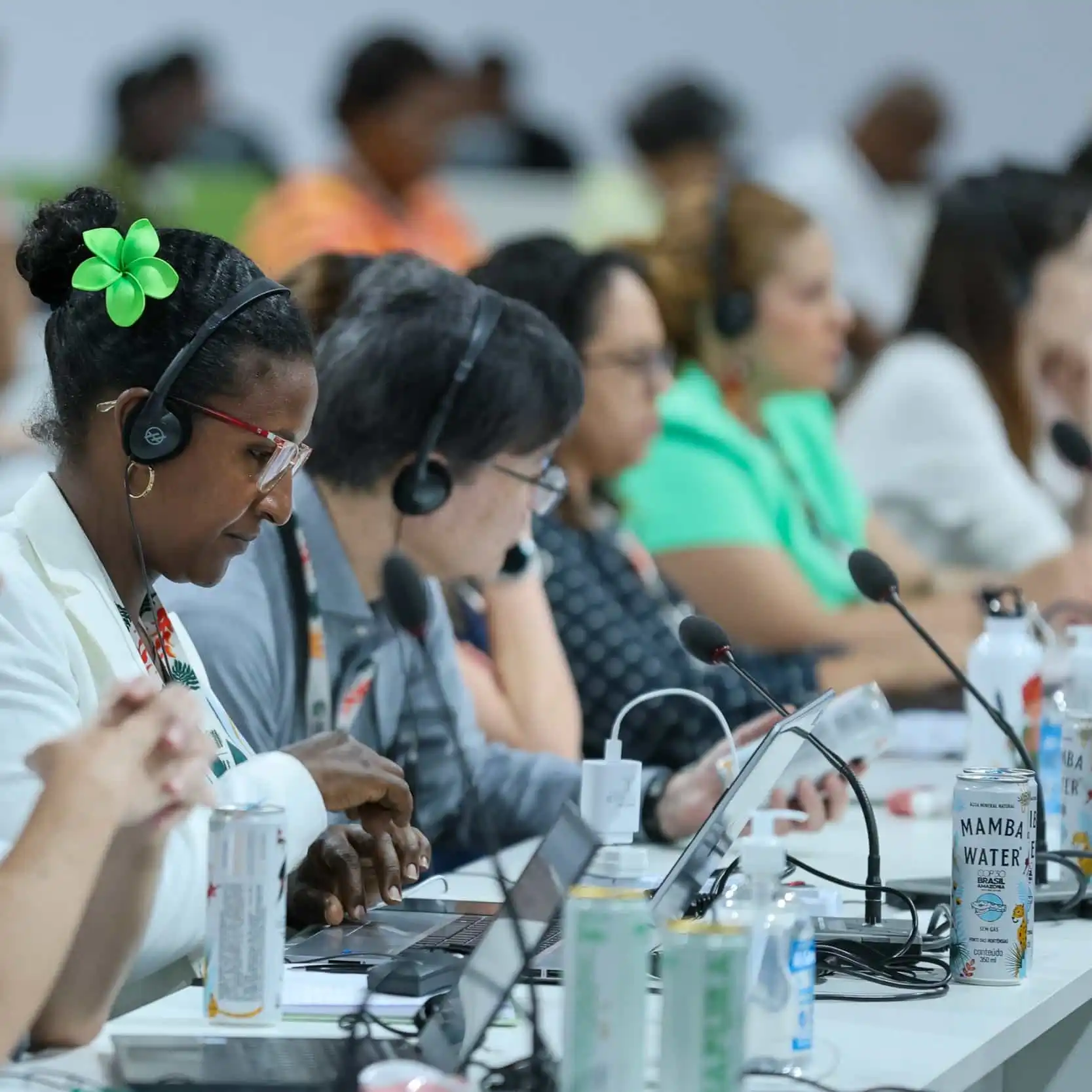 Event attendees listening to language interpretation at COP30