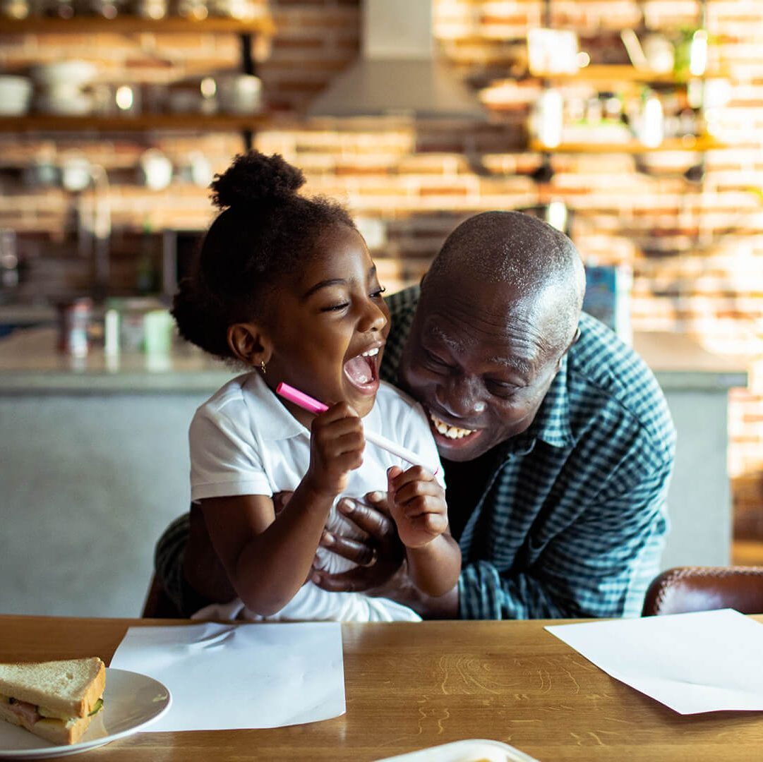 grandfather playing with child in the kitchen