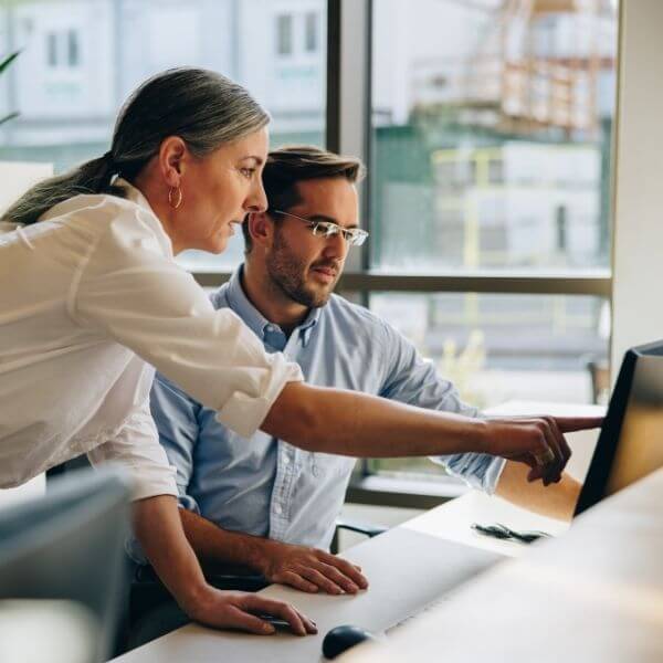 2 people working together at an office desk