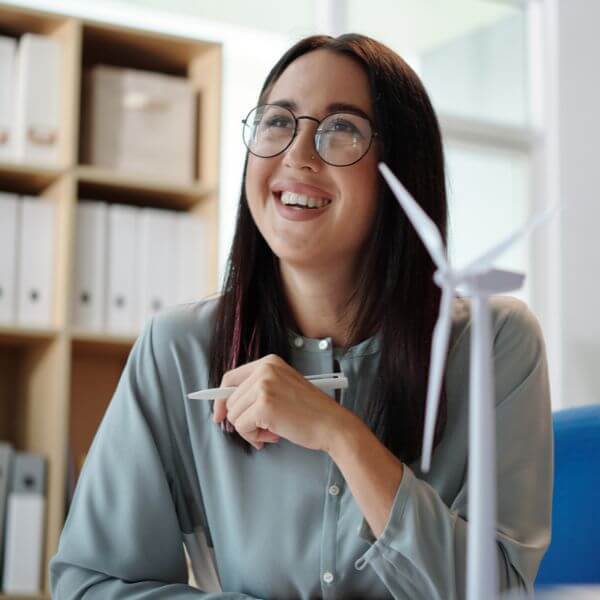 business woman with wind turbine model on desk